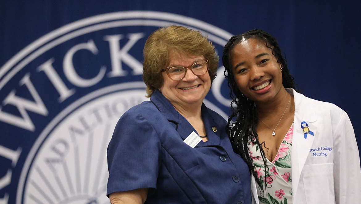 Hartwick College nursing graduate with faculty Melody Best upon receiving her nursing pin