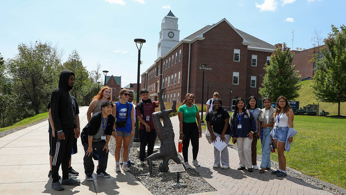 Hartwick College students on Founders' Way around break dancer statue with Golisano Hall in background