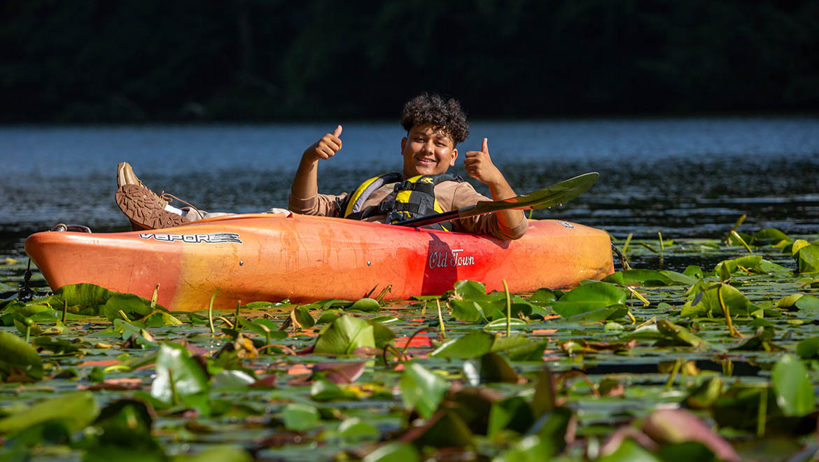 Hartwick College student in kayak on Pine Lake