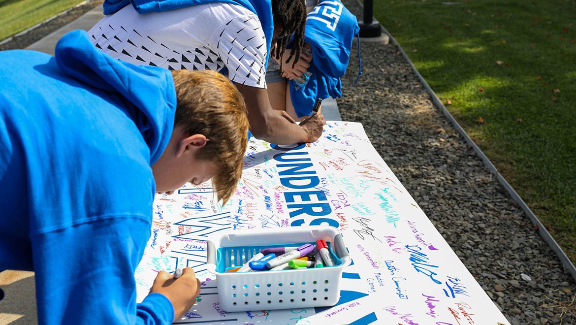 Hartwick College new students signing class banner before First Walk during Wick Week