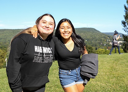 Hartwick College students smiling on Frisbee Field