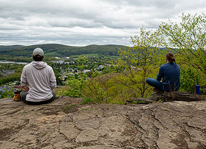 Hartwick College students at top of Table Rock Trail meditating over valley view