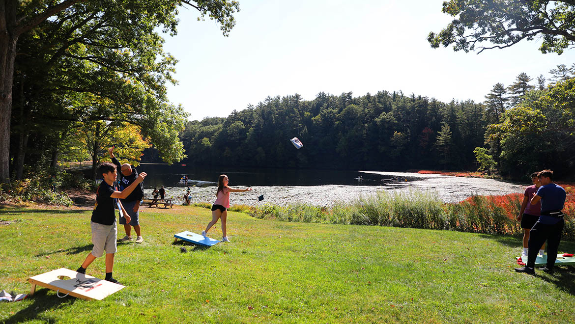 Hartwick College students and families playing lawn games at Hartwick College's Pine Lake Environmental Campus during True Blue Weekend