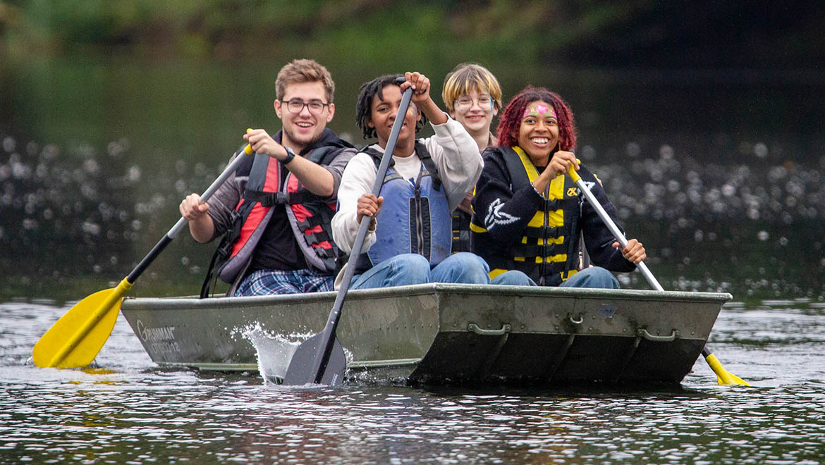 Hartwick College students in boat on Pine Lake