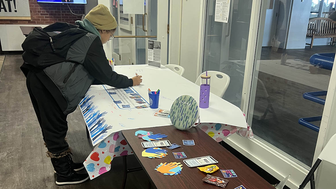 Hartwick College student signing Pledge Against Hate Banner